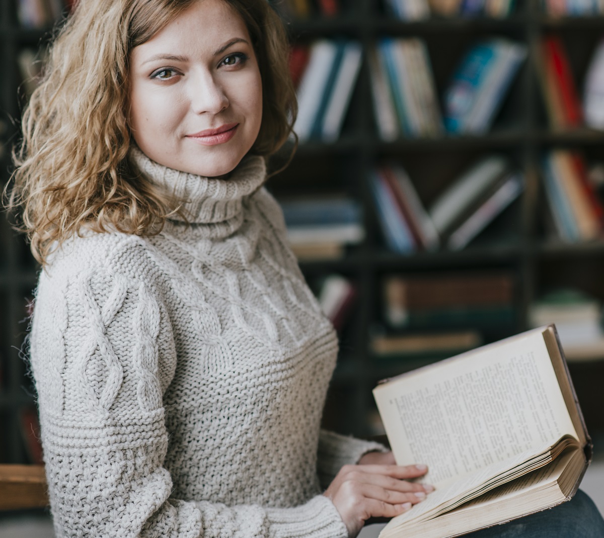 woman-sweater-near-blurred-bookshelves2